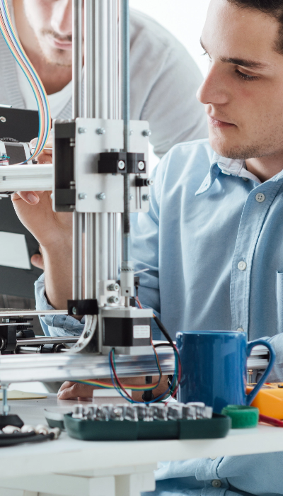 Engineering students using a 3D printer